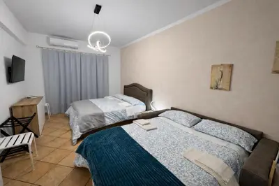 a bedroom with two beds and a tv and a couch at Irpinia 19 Guest House in Rome