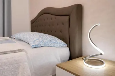 a bed with a blue pillow and a lamp on a table at Irpinia 19 Guest House in Rome