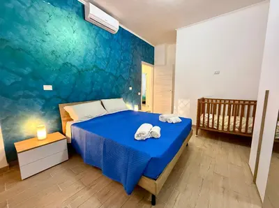 a bedroom with a blue bed with towels on it at Domus Basilica San Paolo in Rome