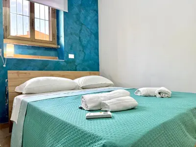 a bed with towels and a cell phone on it at Domus Basilica San Paolo in Rome