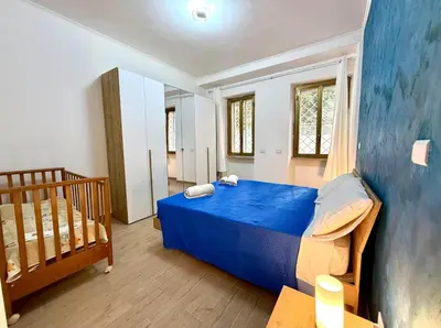 a bedroom with a blue bed and a crib at Domus Basilica San Paolo in Rome
