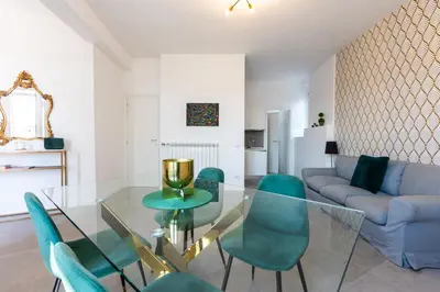 a living room with a glass table and green chairs at Vatican Secret Apartment in Rome