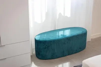 a green ottoman is sitting in a room at Vatican Secret Apartment in Rome