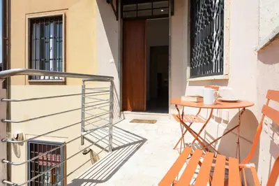 a patio with a table and a chair next to a door at Vatican Secret Apartment in Rome