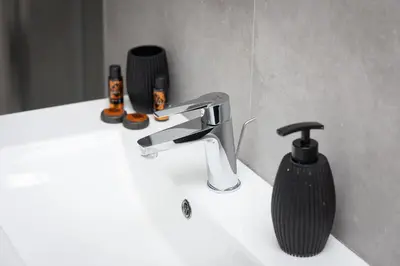 a bathroom sink with a faucet and a soap dispenser at Vatican Secret Apartment in Rome