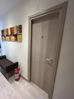 a wooden door in a room with a stool at Vatican Stay Ottaviano in Rome