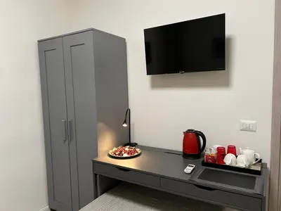 a room with a desk with a tv on a wall at Vatican Stay Ottaviano in Rome