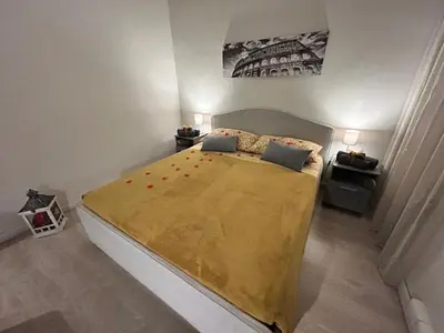 a bedroom with a large bed with a yellow blanket at Vatican Stay Ottaviano in Rome