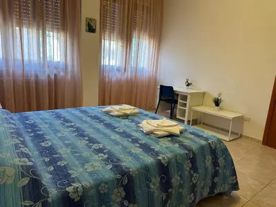 a bedroom with a bed with a table and a desk at Casa per Ferie Eden Cusmano in Rome