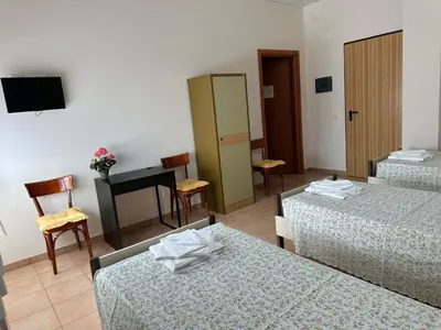 a hotel room with two beds and a television at Casa per Ferie Eden Cusmano in Rome