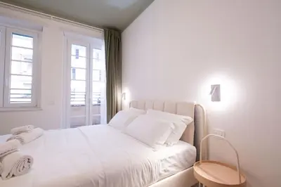 a white bedroom with a white bed with a window at Le Dimore del Duca in Rome