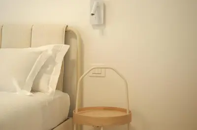 a bed with a wooden nightstand next to a pillow at Le Dimore del Duca in Rome