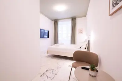 a white bedroom with a bed and a table at Le Dimore del Duca in Rome