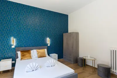 a bedroom with two beds and a blue wall at Vatican Walls Apartment in Rome