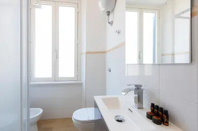 a white bathroom with a sink and a toilet at Vatican Walls Apartment in Rome