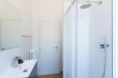 a white bathroom with a shower and a sink at Vatican Walls Apartment in Rome