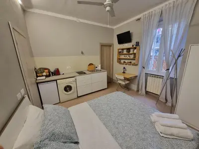 a bedroom with a bed and a washing machine in it at Monolocale luminoso vicino Trastevere in Rome