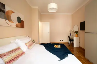 a bedroom with a white bed and a painting on the wall at Modern Apartment near Vatican & Foro Italico - Rome in Rome