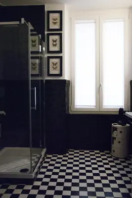 a bathroom with a shower and a checkered floor at App Leoncino Design Apartment in Rome in Rome
