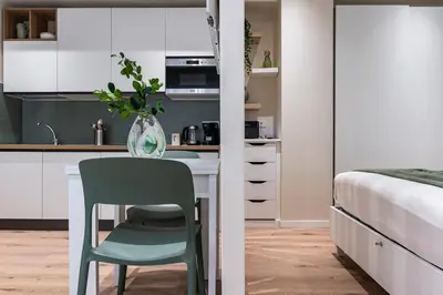 a kitchen with a table and a chair next to a bed at Casa Bressan in Rome