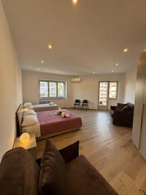 a bedroom with a large bed and a living room at Giorgi House in Rome