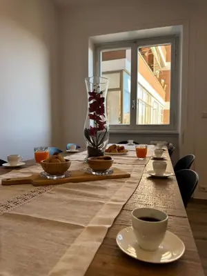 a long table with a vase and cups on it at Giorgi House in Rome
