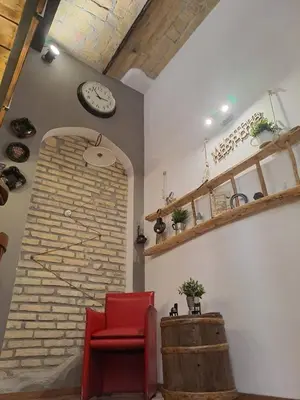 a room with a red chair and a brick wall at FCR Rome Apartments Sweet Nest of Love in Rome