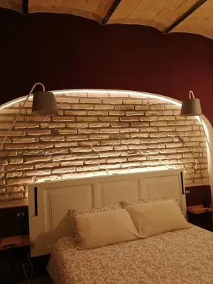 a bedroom with a bed with a brick wall at FCR Rome Apartments Sweet Nest of Love in Rome