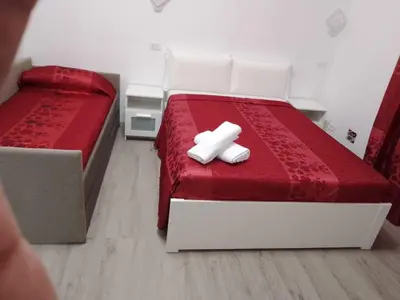 a bedroom with two beds with red sheets and white pillows at Euromoon in Rome