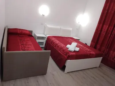 a bedroom with two beds with red sheets and two candles at Euromoon in Rome