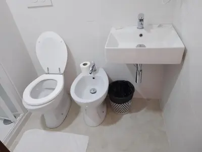 a white bathroom with a toilet and a sink at Euromoon in Rome