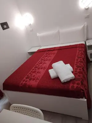 a red bed with two white pillows on it at Euromoon in Rome
