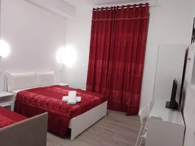 a bedroom with a red bed and a red curtain at Euromoon in Rome
