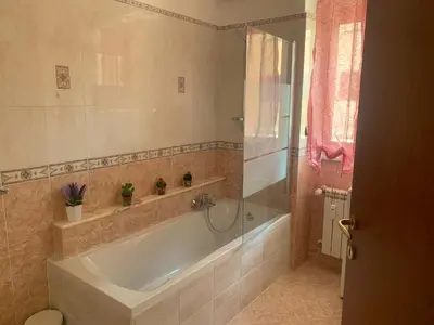 a bathroom with a bath tub and a shower at Lilly's Apartment a 5 minuti Metro C in Rome