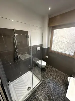 a bathroom with a glass shower and a toilet at Dimora Battistini in Rome
