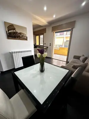 a living room with a table with a vase of flowers on it at Dimora Battistini in Rome