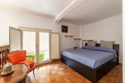 a bedroom with a bed and a table and a chair at GuestHost - Historic Center Apartment Lungotevere in Rome