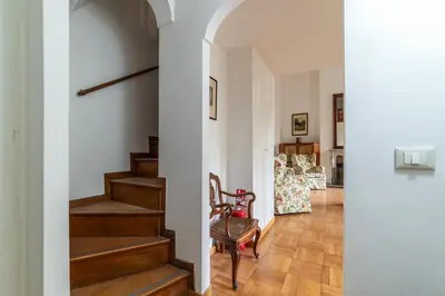 a hallway with stairs and chairs in a house at GuestHost - Historic Center Apartment Lungotevere in Rome