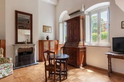 a living room with a table and a fireplace at GuestHost - Historic Center Apartment Lungotevere in Rome
