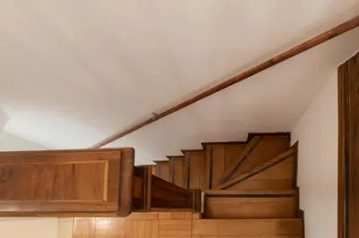 a stairway with wooden stairs and a white ceiling at GuestHost - Historic Center Apartment Lungotevere in Rome
