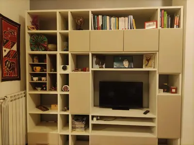 a white book shelf with a television in it at camera singola al Pigneto in Rome