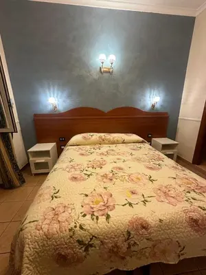 a bedroom with a bed and two lights on the wall at Near Termini station in Rome