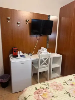 a room with a desk with a television on a wall at Near Termini station in Rome