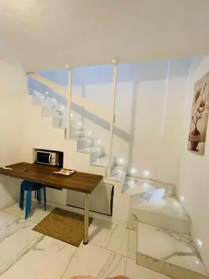 a room with a wooden table and a staircase at Loft Flower Colosseum in Rome