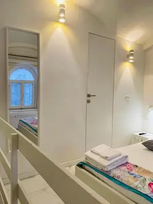 a bathroom with a mirror and a bed with towels at Loft Flower Colosseum in Rome