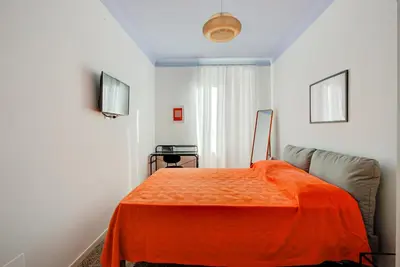 a room with a bed with an orange blanket at Casa Chiro 79 in Rome