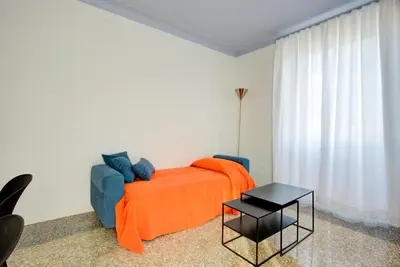 a bedroom with a bed with an orange blanket and a table at Casa Chiro 79 in Rome