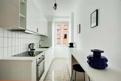 a white kitchen with a sink and a counter at Casa Chiro 79 in Rome