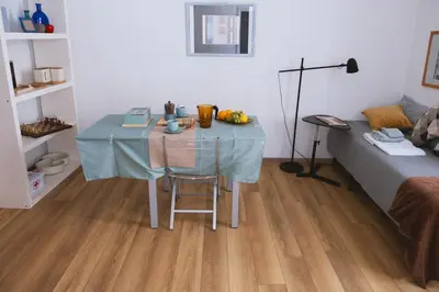 a small table in a room with a bed and a blue table cloth at Charming 3-Guest Apt in San Giovanni Landmark in Rome