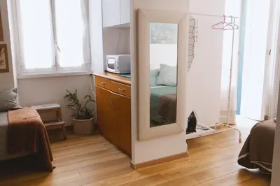 a mirror in a room with a bed and a microwave at Charming 3-Guest Apt in San Giovanni Landmark in Rome